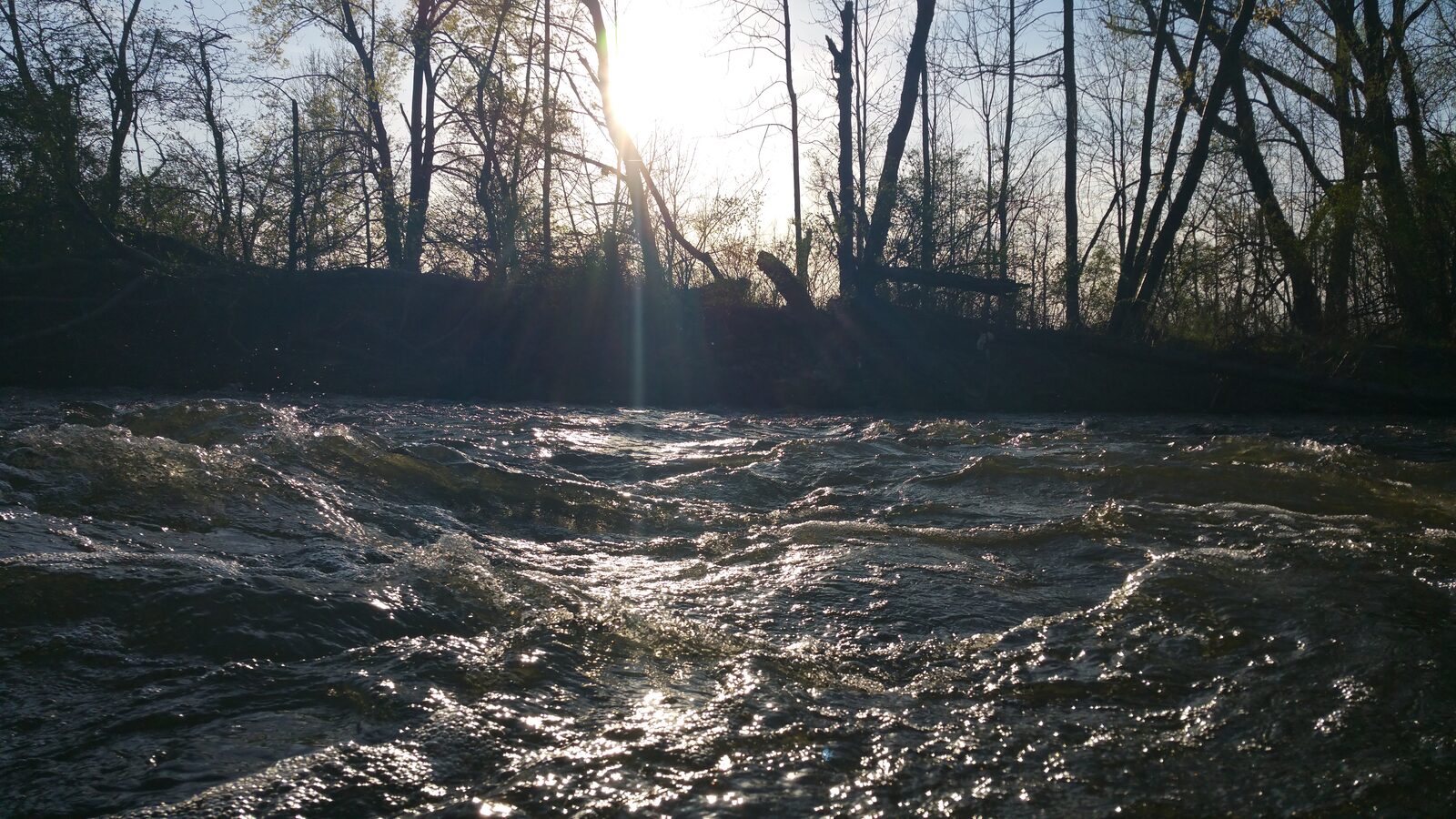 Late sunlight scattering across the moving surface of a river